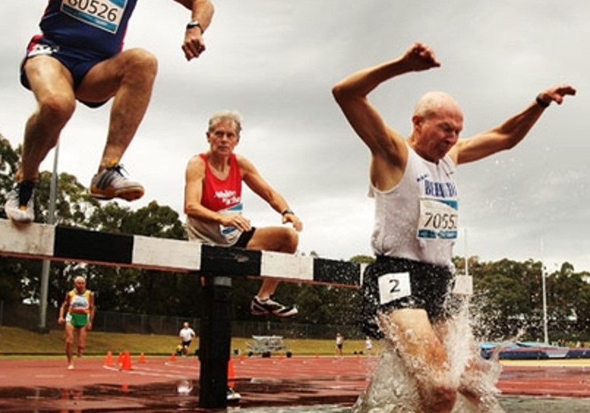 Adultos mayores saltando vallas en carrera